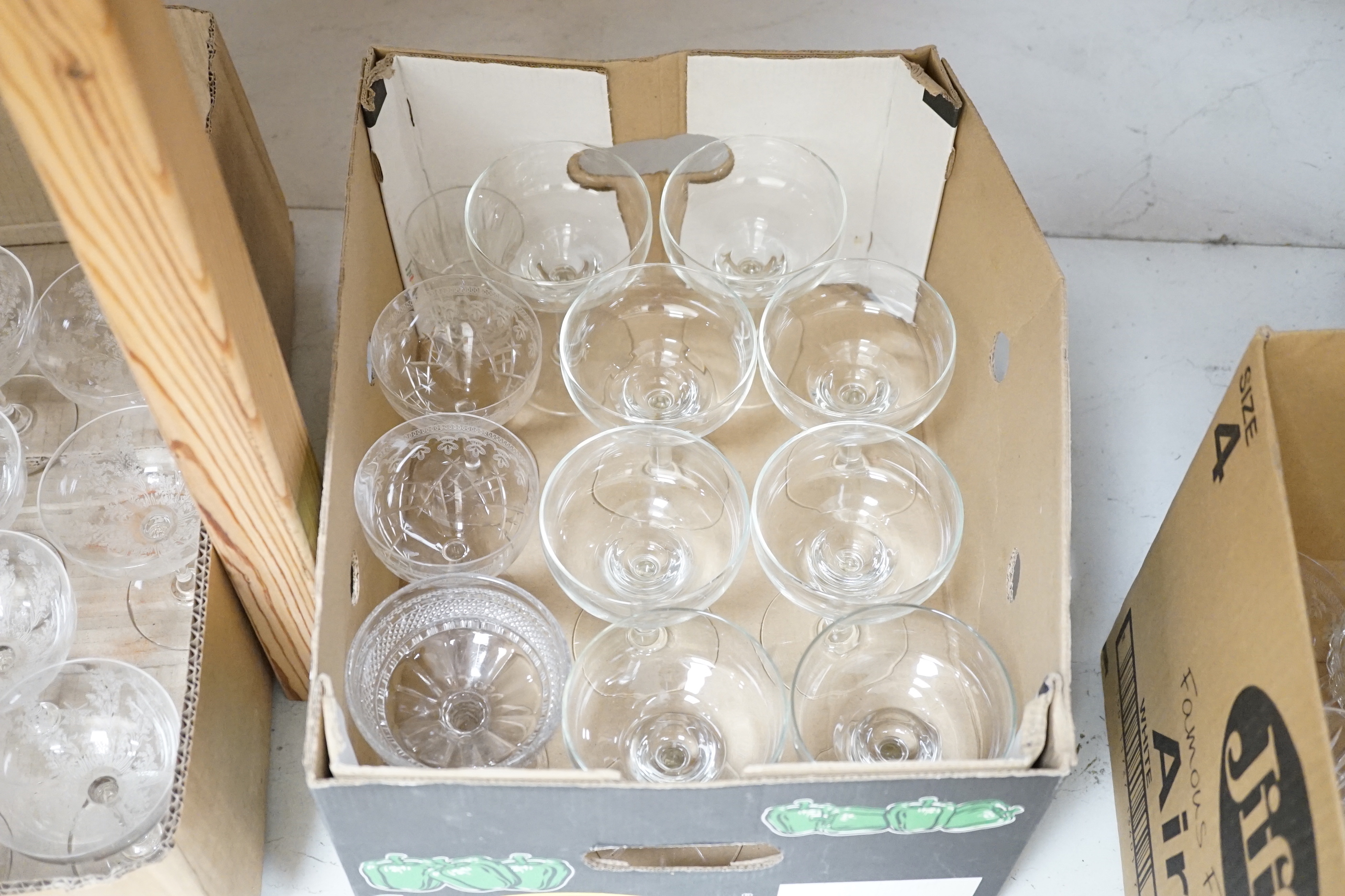 A collection of glassware including nine coupe glasses etched with butterflies and leaves